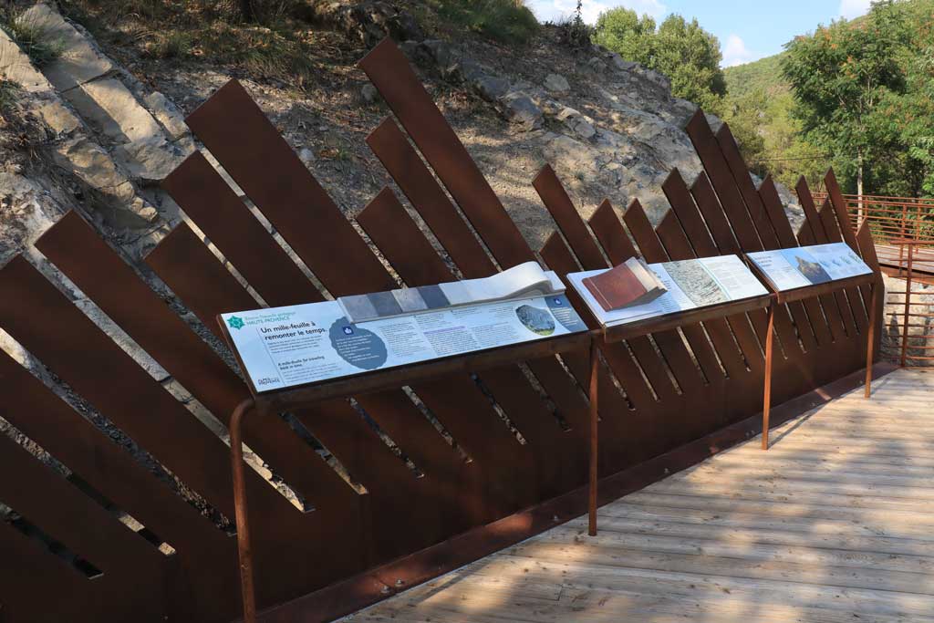 Strates g&eacute;ologiques repr&eacute;sent&eacute;es par une frise m&eacute;tallique.